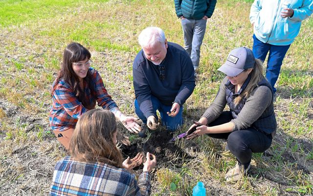 People in a circle studying soil.