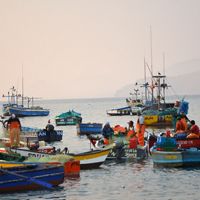 Several small fishing boats with fishers crowded in the water.
