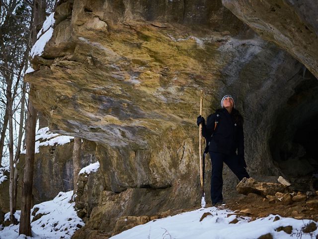 Hiker stands in opening of large rock outcropping at Edge of Appalachia Preserve.