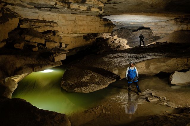 Cory Holliday, Tennessee TNC's cave and karst specialist, crosses a stream in Wolf River Cave. 