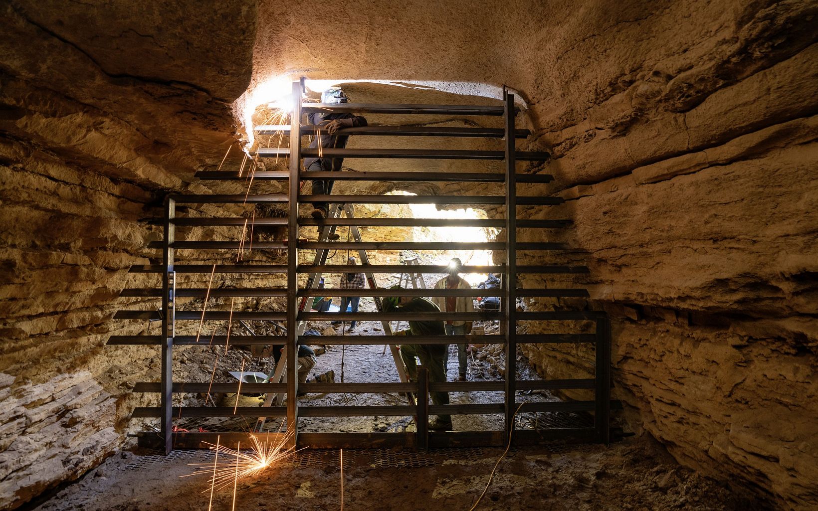 
                
                  Restoration Kristen Bobo welds a bat-friendly cave gate on one
of the entrances to Piper Cave. The Nature Conservancy bought the cave and is restoring it to once again support bats.
                  © Stephen Alvarez
                
              