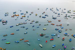 Colorful fishing boats sitting on still blue water.