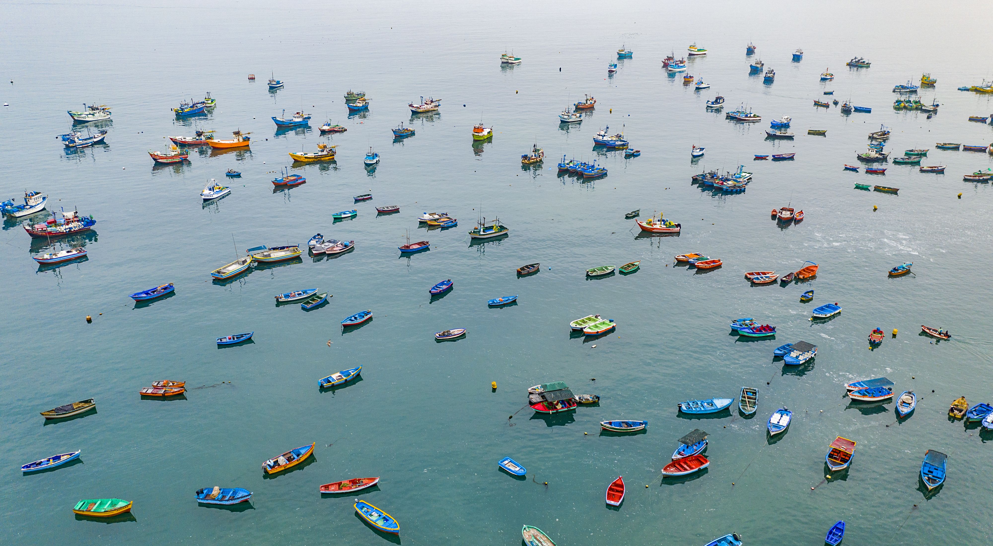 Colorful small boats are anchored in calm water