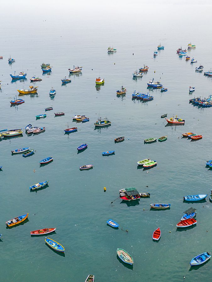 Barcos de acabamento coloridos sentados na água azul