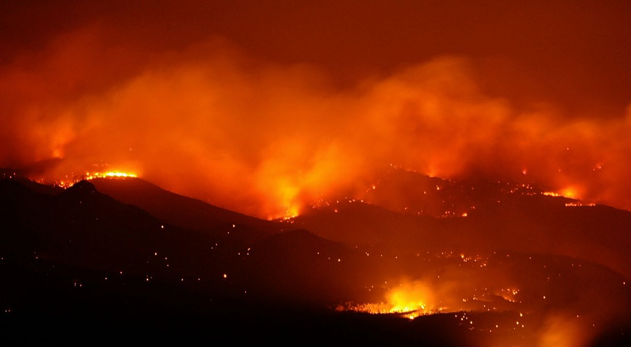 Wildfire spreading over a mountain range.