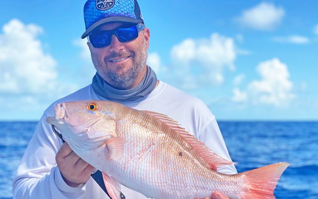 Florida fisheries manager David Moss holds a large freshly-caught mutton snapper. 