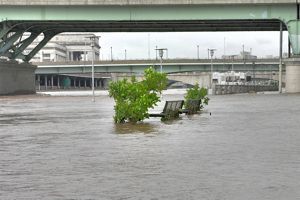 city benches on a street are surrounded by flood water