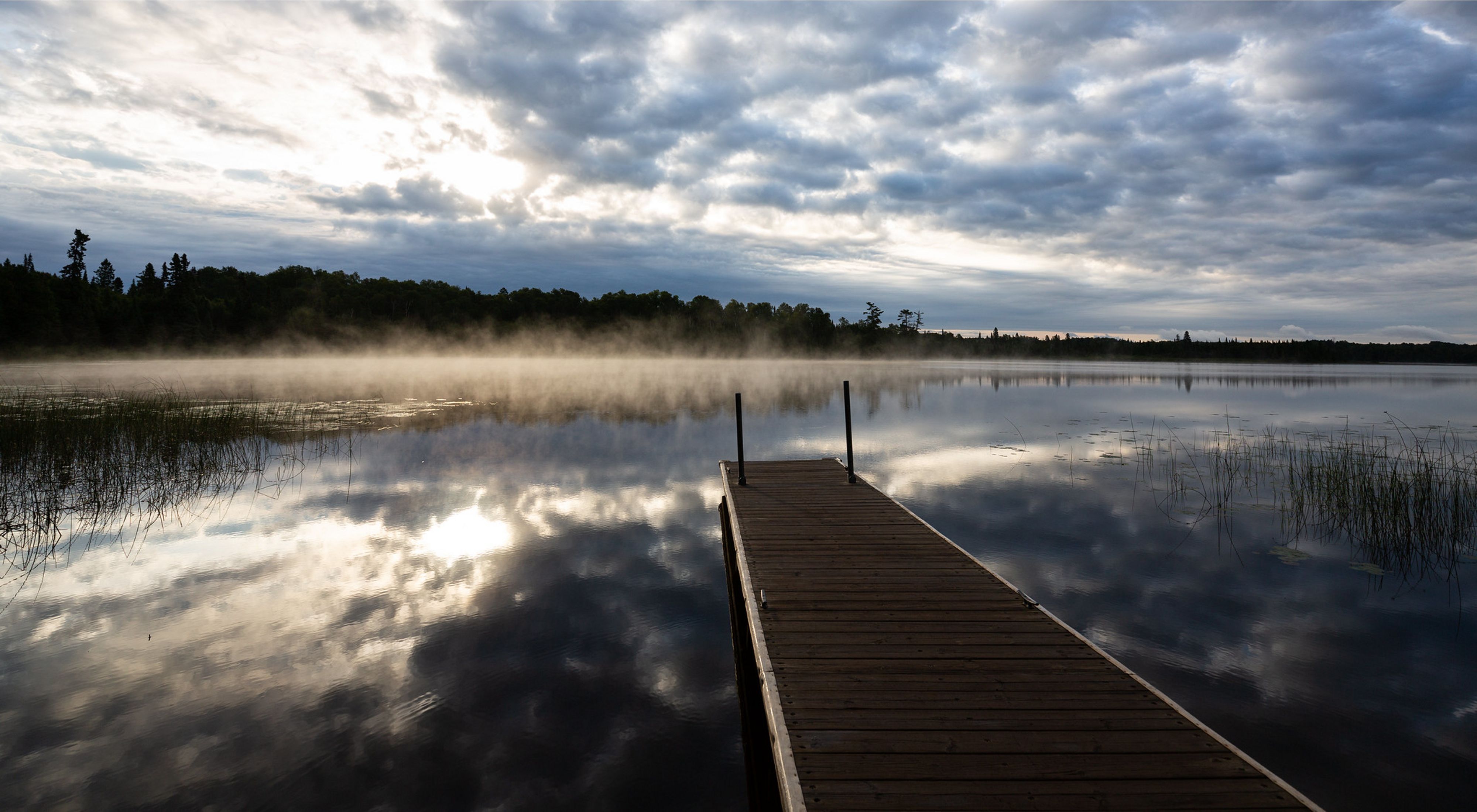 A dock on a foggy lake.
