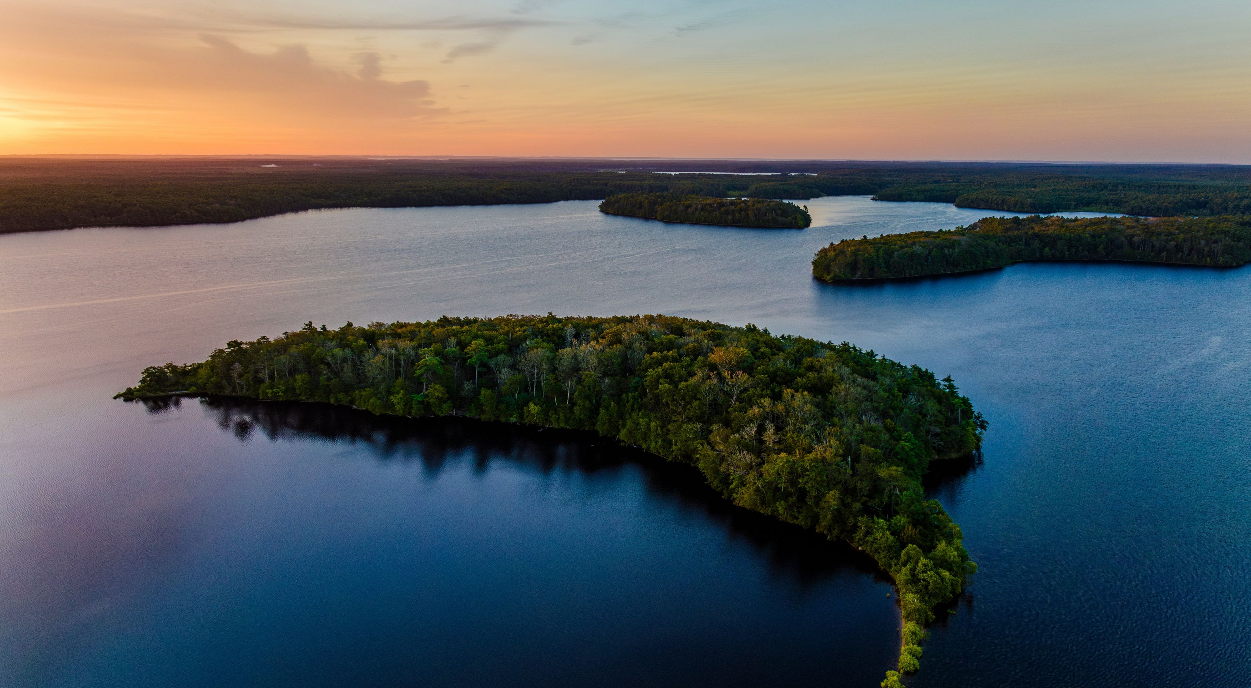 Aerial view of a pond with some islands and shoreline at sunrise