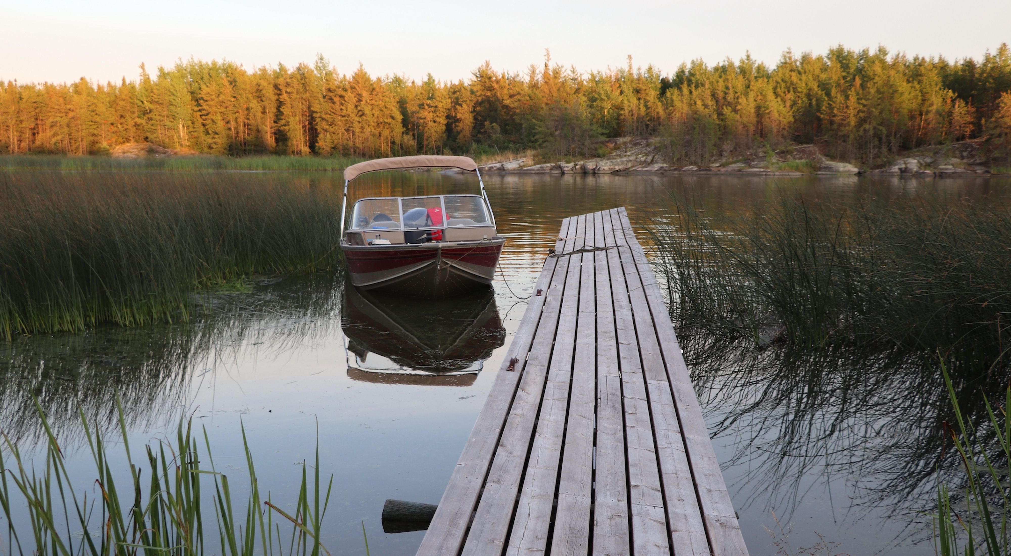 Boat near a dock on a lake in boreal Manitoba.