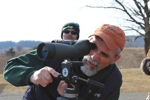 A person looks through a telescope into the distance. 