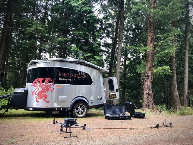 a drone on the ground with a trailer in the background.