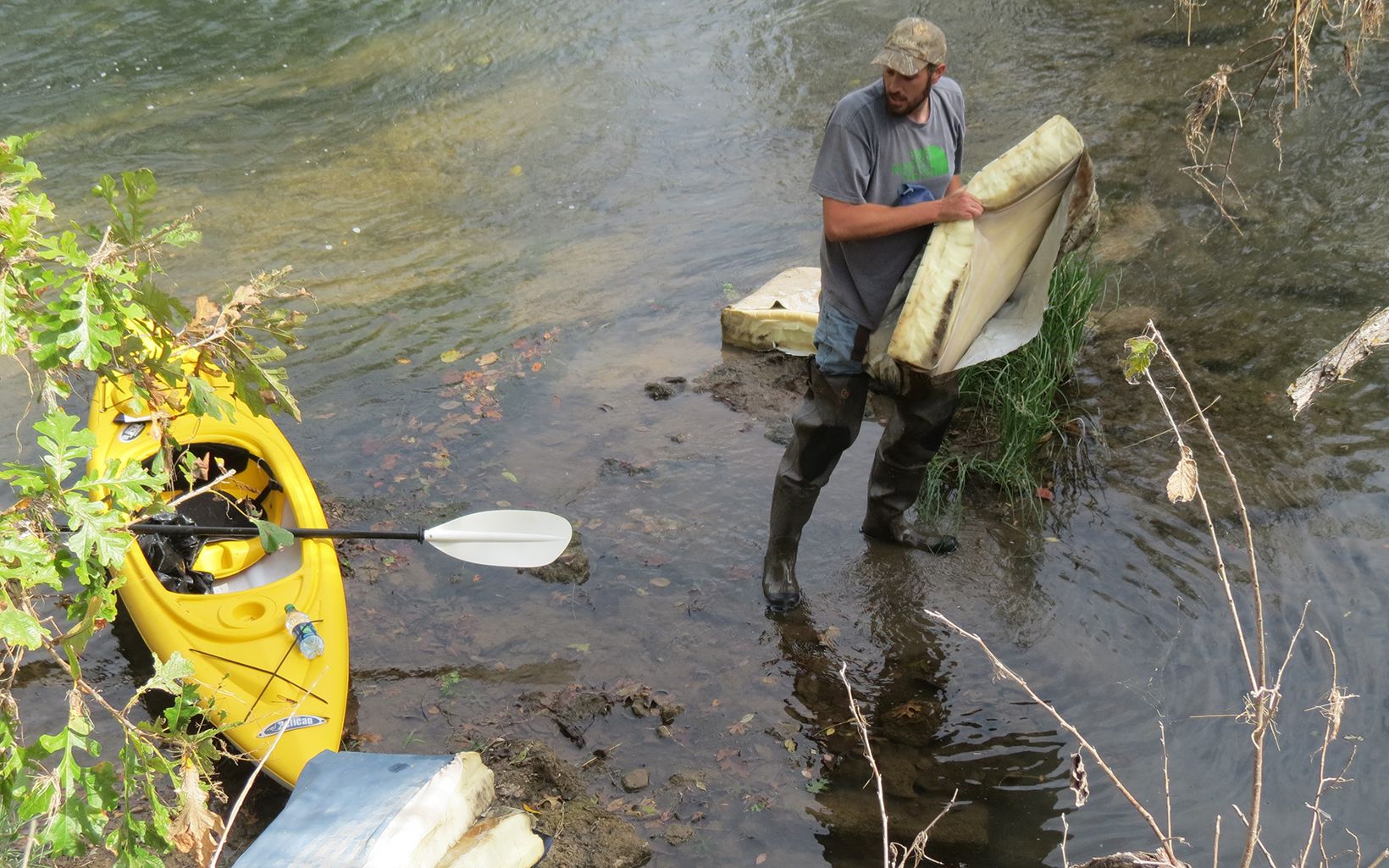 Volunteer cleaning up along Blue River 