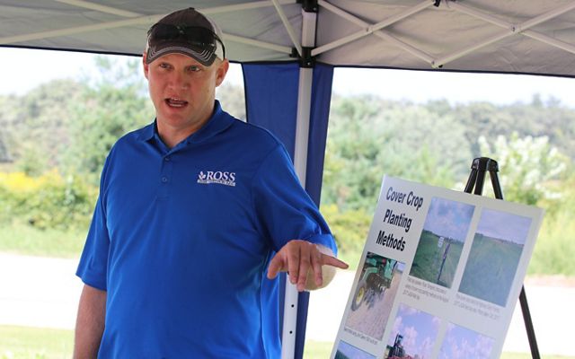 Man in blue shirt giving a presentation on soil health.