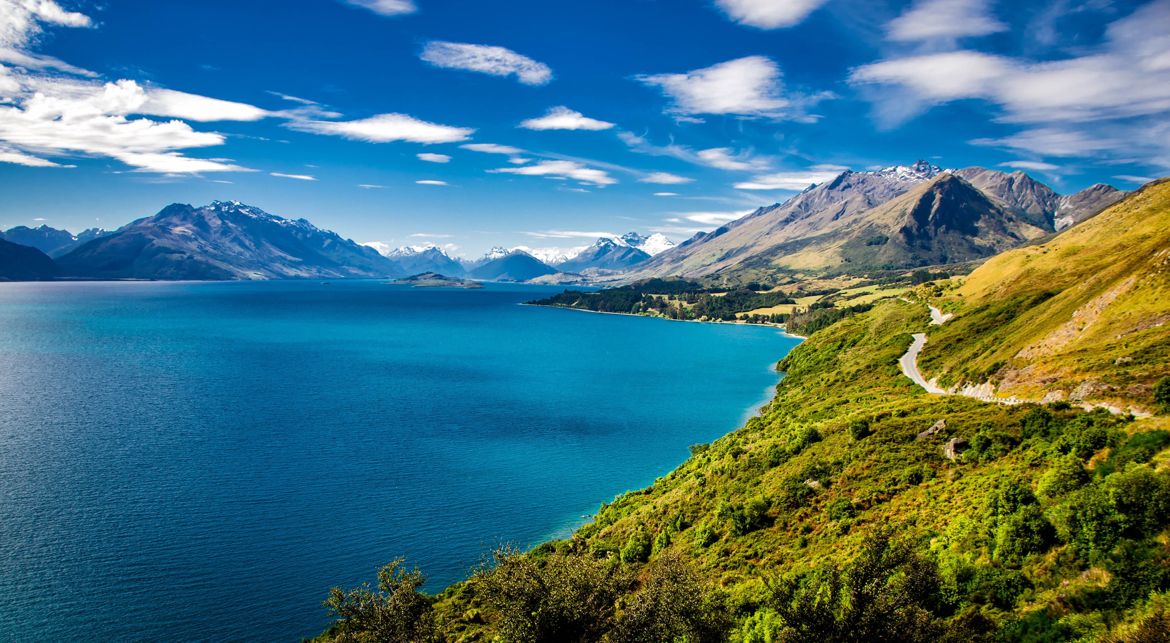 Summer view of Lake Wakatipu and the road from Queenstown to Glenorchy.  Southern Alps mountains in the distance.