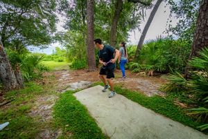 Two people playing frisbee golf in a park.