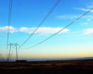 Photo of electric utility lines against a blue sky.