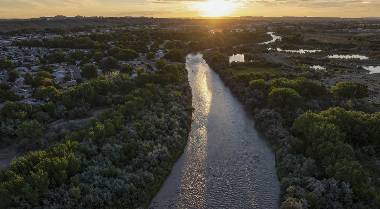 Ariel view of a river during sunset with lush trees and vegetation all around.