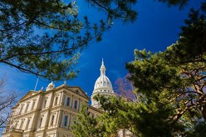 The Michigan Statehouse against a bright blue sky. 