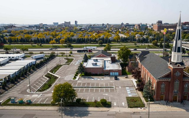 Aerial image of the church with the city of Detroit spread out behind it. 
