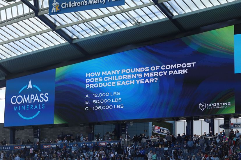 A video board with a blue and green background and text asking the question, How many pounds of compost does Children's Mercy Park produce each year? with three answers to choose from.