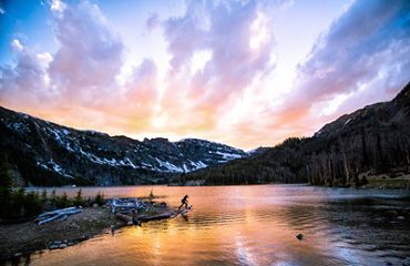 SOUTH MEADOW CREEK LAKE. Colorida puesta de sol durante una cálida noche de verano en South Meadow Creek Lake, en las montañas Tobacco Root, Montana.