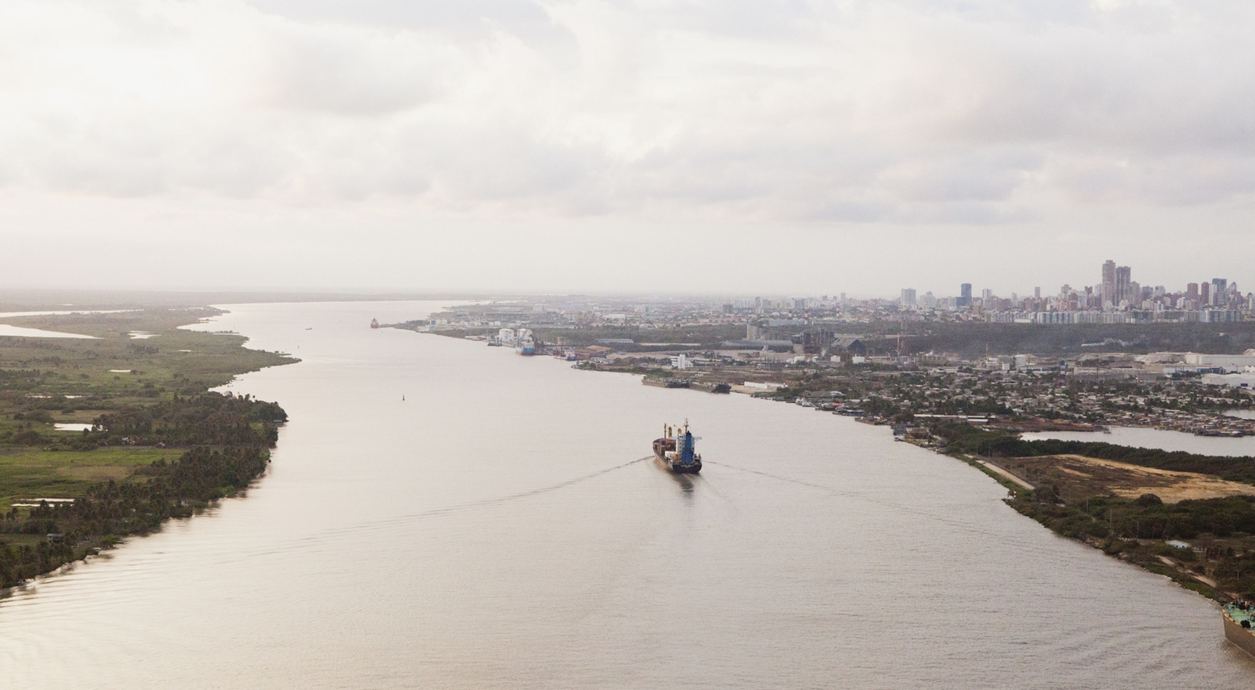 (TNC LICENSE) February 2017. Aerial view of the city of Barranquilla and Magdalena River. Bocas de Ceniza is the mouth of the Magdalena River in the Caribbean Sea. It gets its name from the oceans dusky color. At present, the river flows into the sea through an artificial canal built in the 1930s. Sediments have become a major issue intervening with navigability and accessibility for ships to enter Barranquilla. Photo credit: © Juan Arredondo