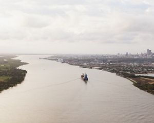 (TNC LICENSE) February 2017. Aerial view of the city of Barranquilla and Magdalena River. Bocas de Ceniza is the mouth of the Magdalena River in the Caribbean Sea. It gets its name from the oceans dusky color. At present, the river flows into the sea through an artificial canal built in the 1930s. Sediments have become a major issue intervening with navigability and  accessibility for ships to enter Barranquilla. Photo credit: © Juan Arredondo