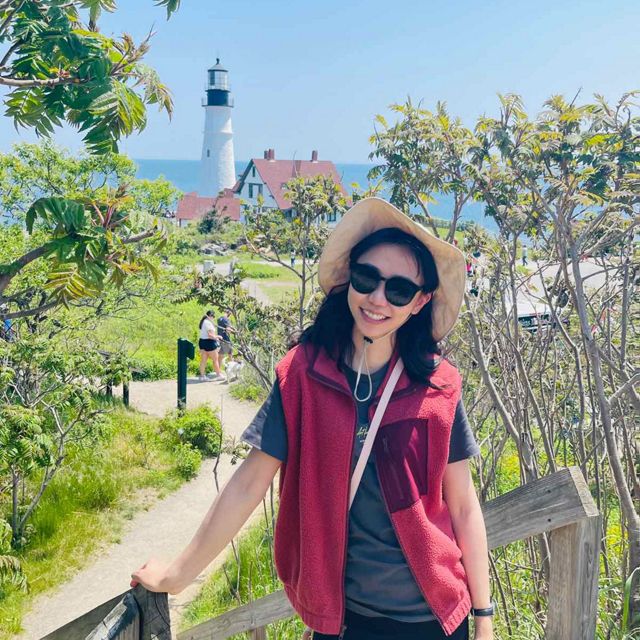 Marla Ganbat poses in front of a Maine lighthouse.