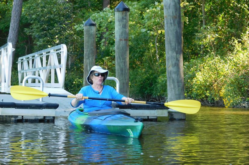 Deborah Dalley Phillips paddles in a kayak in the water.