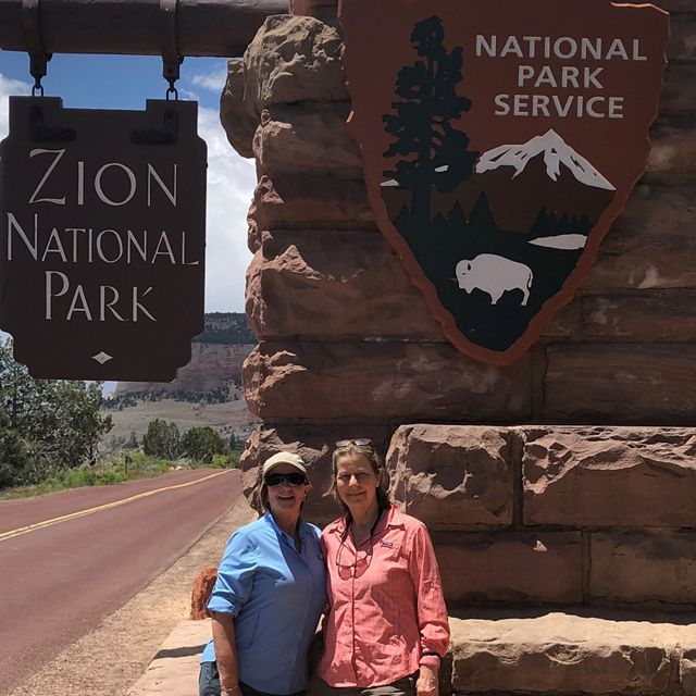 Two women at the gate of a national park on a sunny day