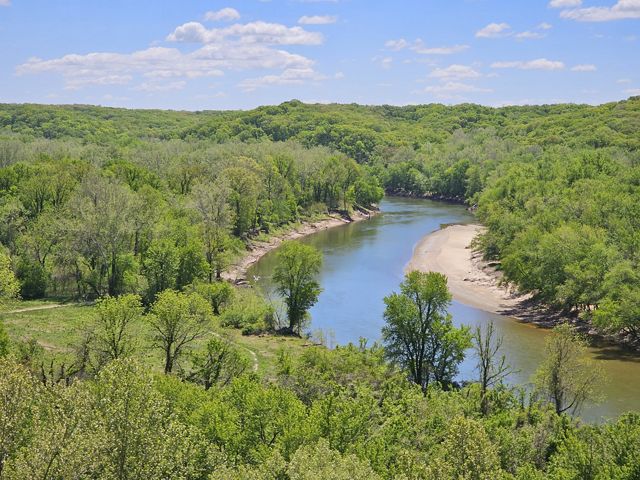 A zoomed out shot of the Meramec River surrounded by trees.