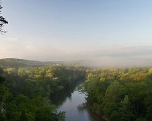 An aerial view of a river running through a forested area.