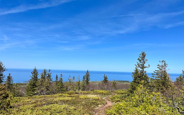 A trail at Helmut and Candis Stern Preserve at Mt. Baldy in Eagle Harbor, Michigan overlooks Lake Superior on a clear day. 