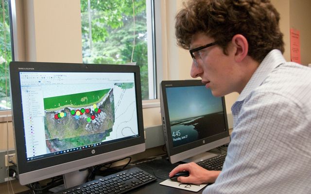 Student researcher stitches together map data collected by drone.