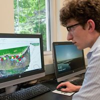 Student researcher stitches together map data collected by drone.
