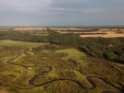 A river winding through a prairie landscape near agriculture fields.