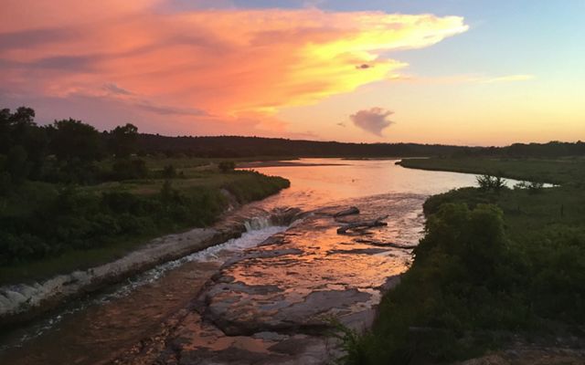 The sun rises over the winding river at the Niobrara Valley Preserve, the largest tract of intact grasslands, which offers climate resiliency.