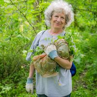 Volunteer holds a bag of invasive garlic mustard at Big Darby Headwaters Nature Preserve.