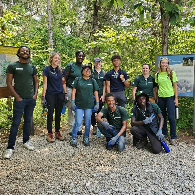 Group of Ohio Groundwork Ohio River Valley Green Team members smiles for camera at Edge of Appalachia trailhead in forest.