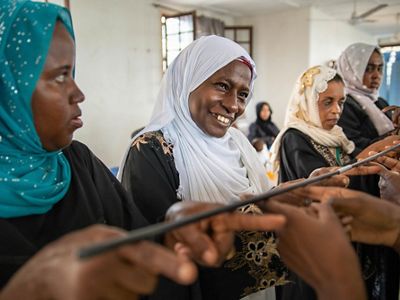 women hold a stick with fingers