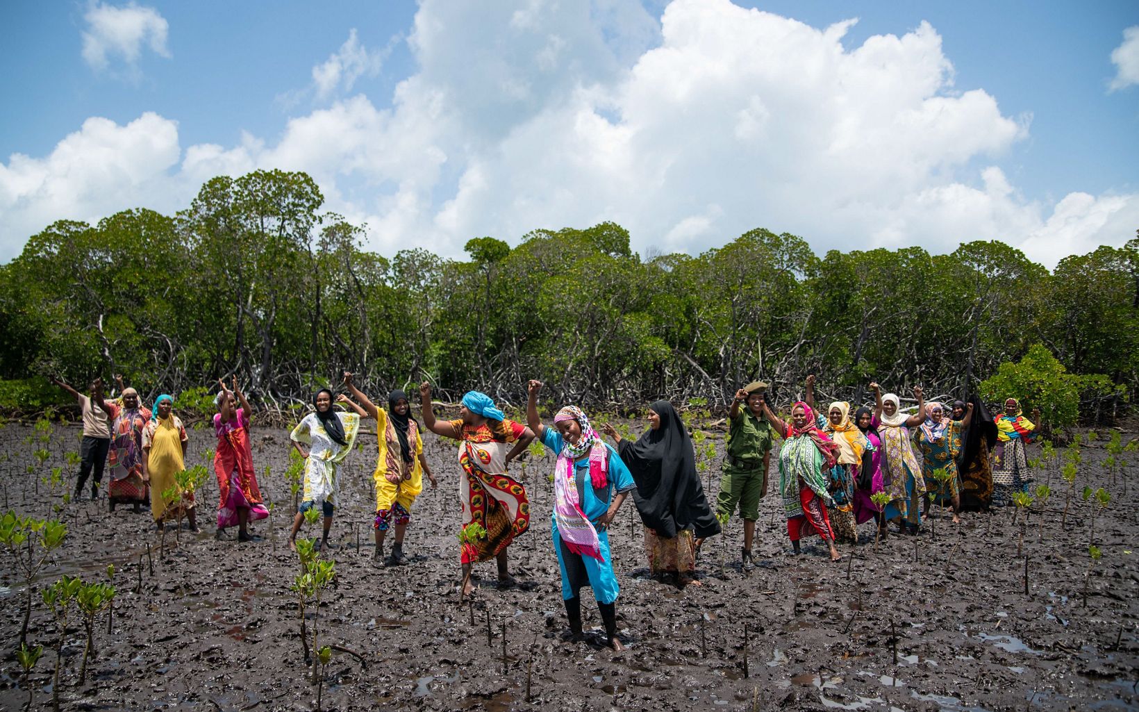 women standing in mud