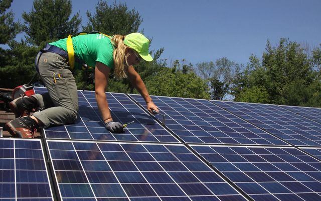 Woman installing solar panels. 