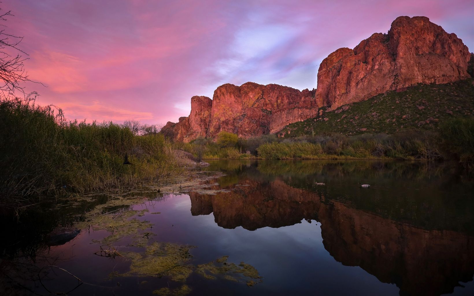 Landscape of a sunset over the Salt River with mountains reflecting on water. 