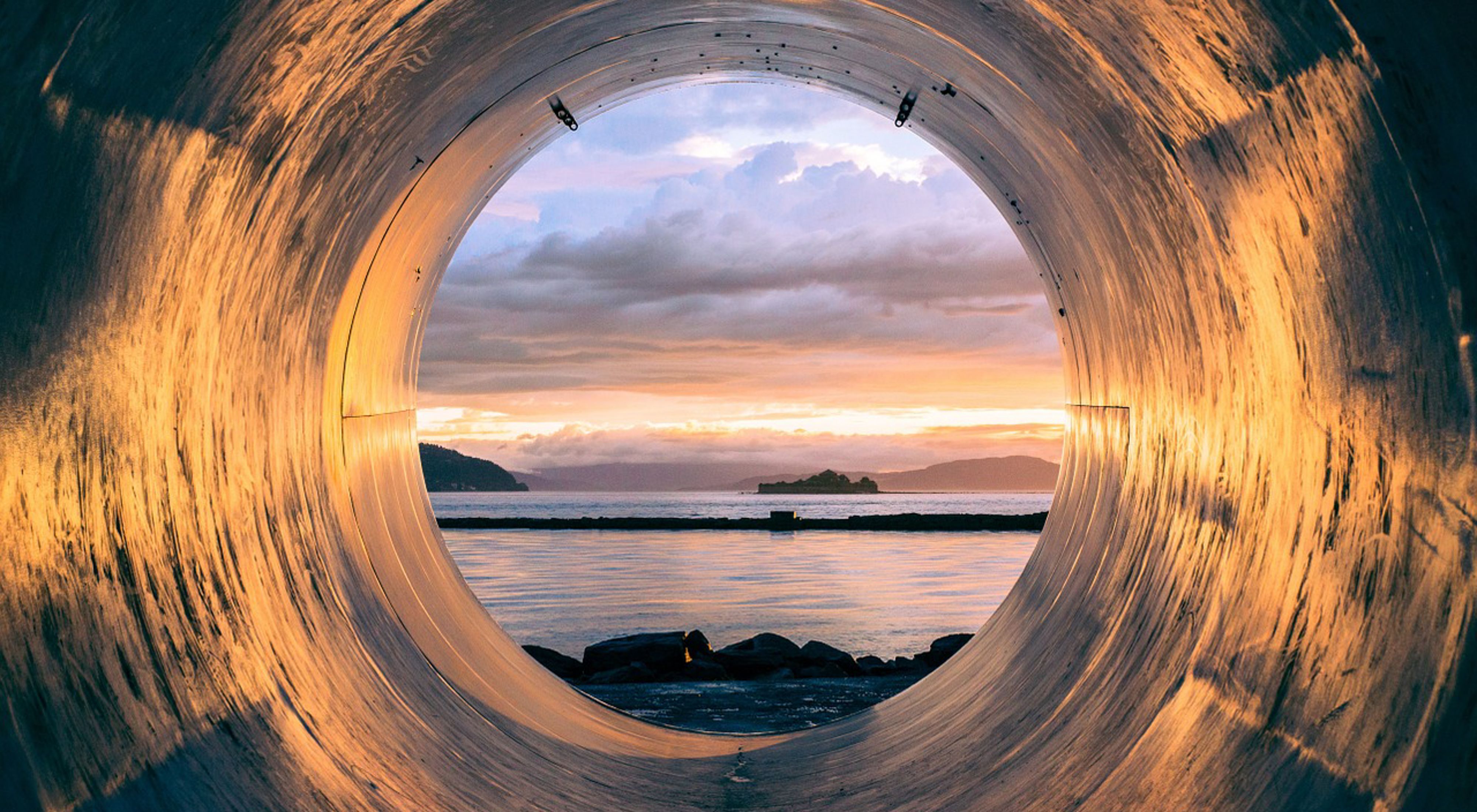 Sewage pipe with sunset in the background.