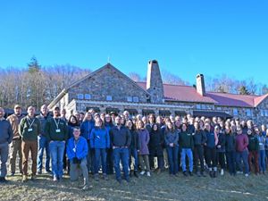 Group photo of TNC VA staff. A large group of people stand together outdoors in front of Mountain Lake Lodge in Pembroke, VA during the chapter's annual staff retreat.