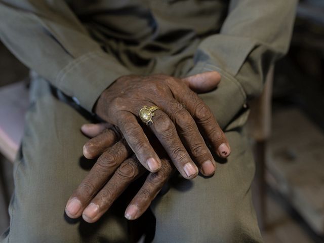 Closeup of Amar Singh's weathered hands, including an amputated index finger on his left hand.