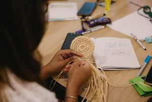 A woman weaves during a workshop.