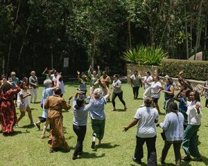 A group of people participate in an outdoor activity and run across grass.