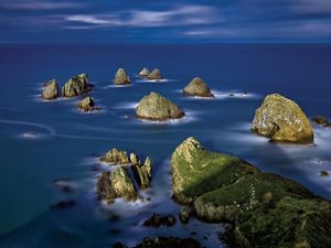  A coast with large boulders dotting the waters.